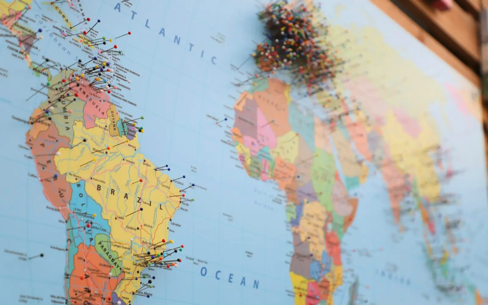 Wall map of the world with pins marking locations across the Atlantic