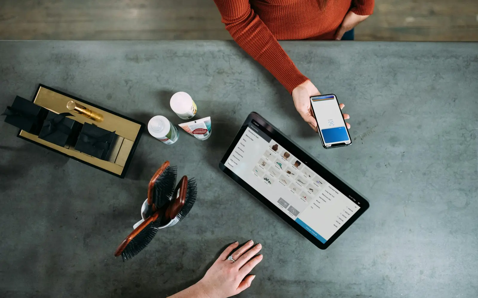 Tablet point-of-sale on a cafe counter while a customer pays with a phone
