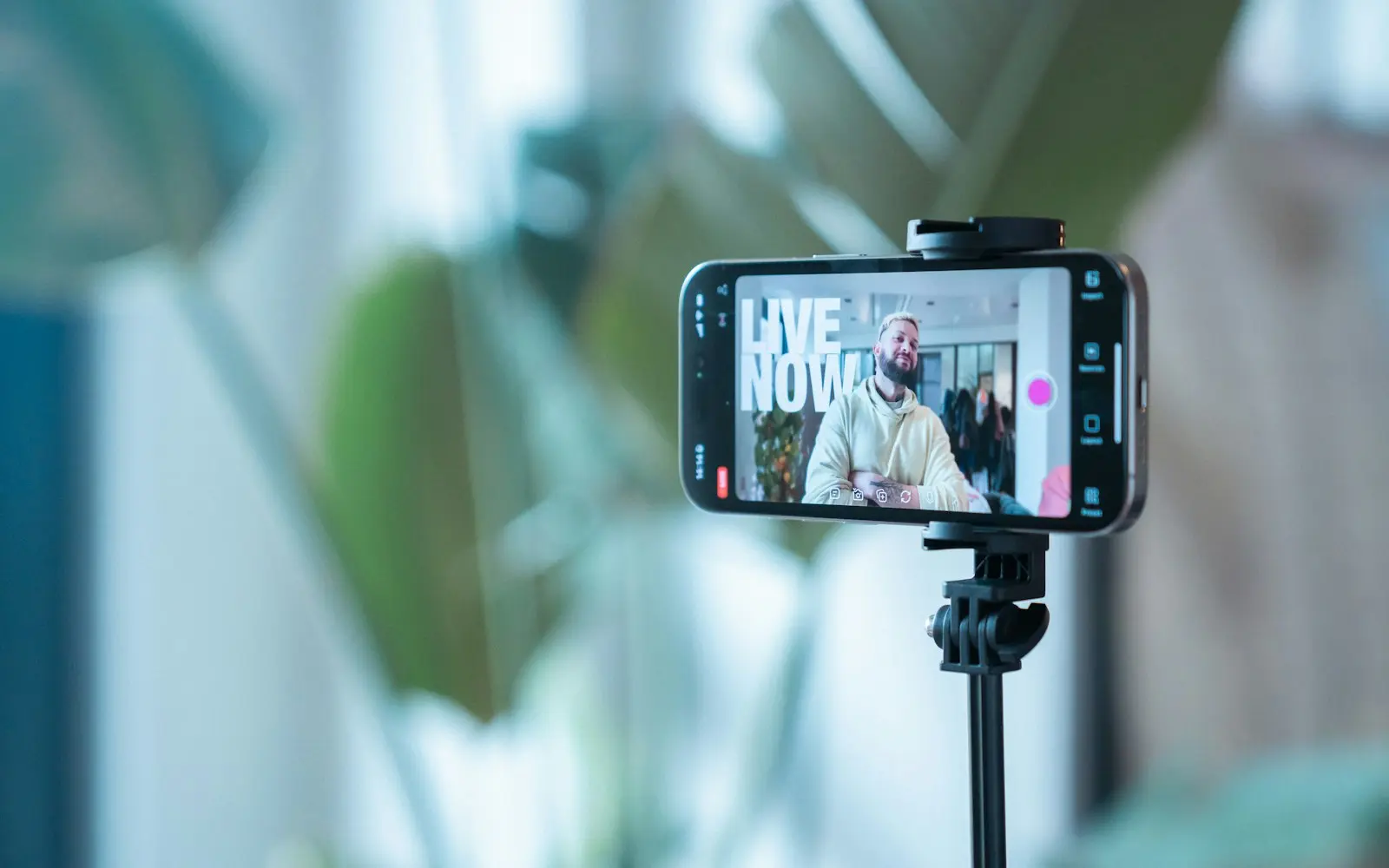 Smartphone on a tripod recording a man speaking during a live stream