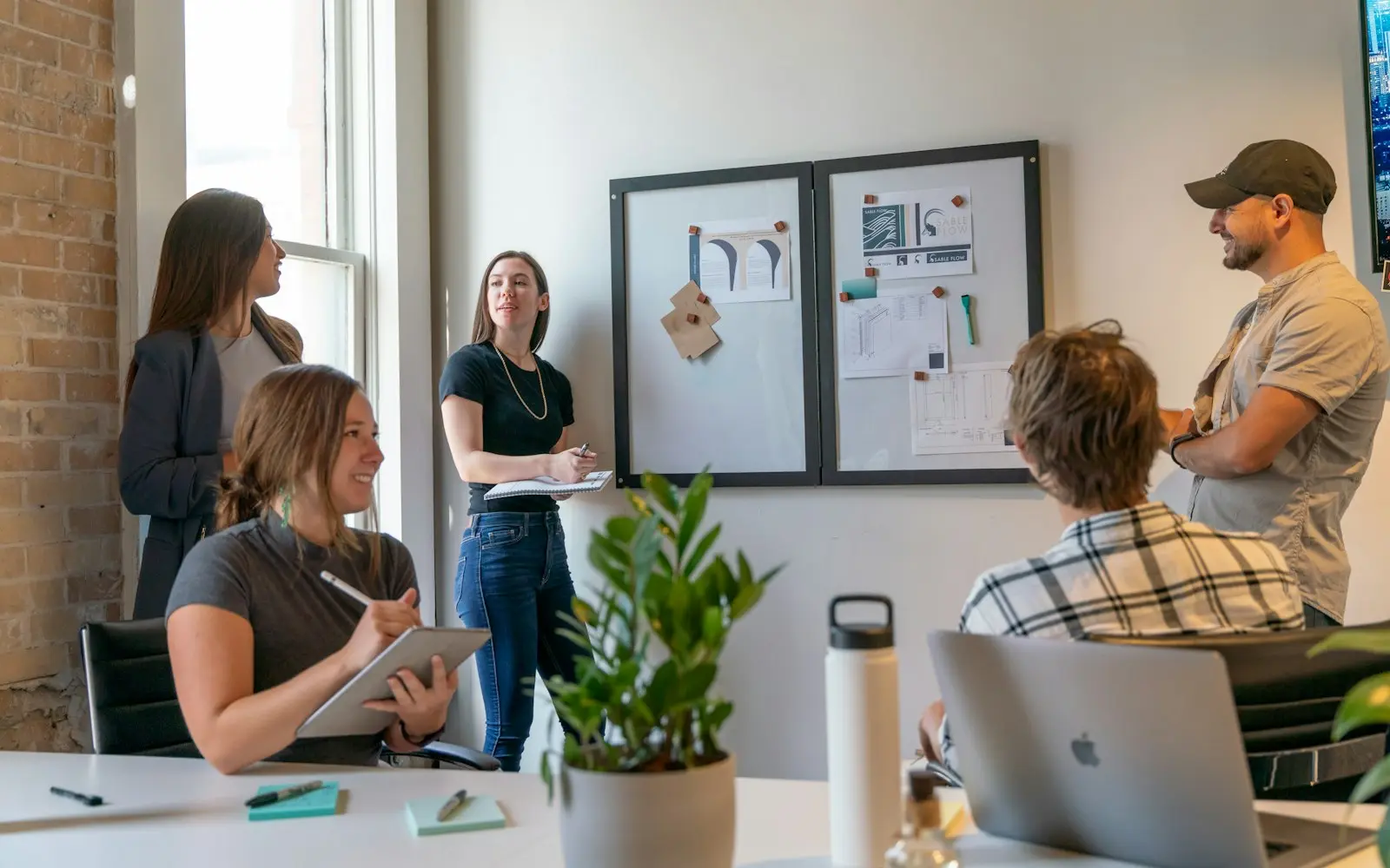 Small group of colleagues meeting in a sunlit modern workspace